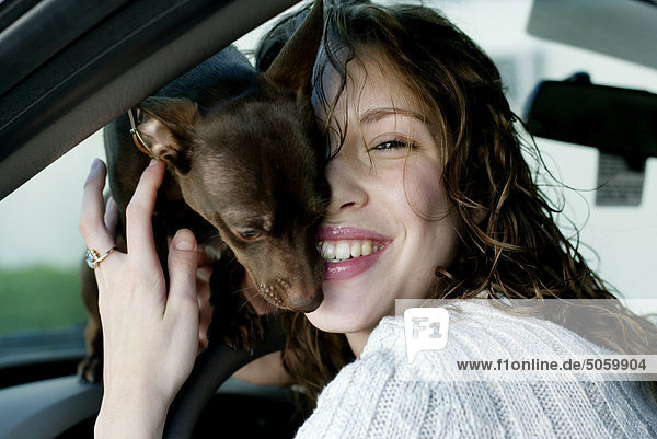 Portrait einer Frau in Auto mit Hund