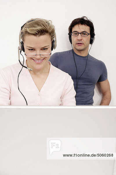 Weiblich working auf Laptop-Computer und Blick auf ihr Mann