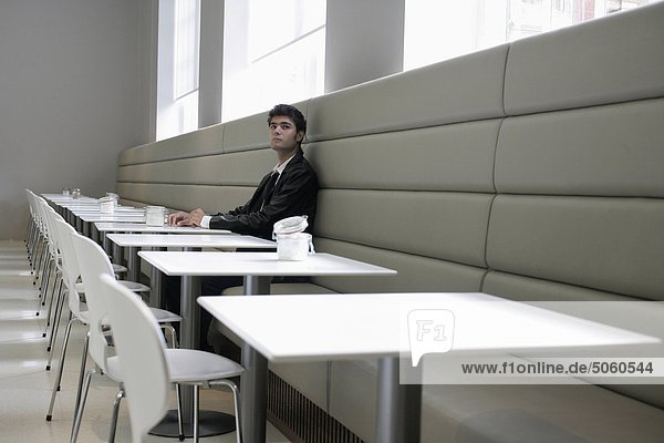 Junger Mann sitzt in einem Café