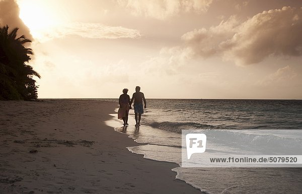 Malediven Ari Atoll senior Couple Wandern am Strand bei Sonnenuntergang