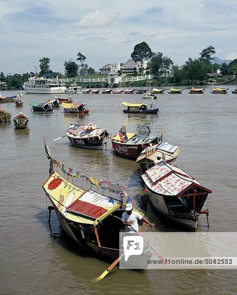 Local boats on the Sarawak river in front of the Istana   Kuching  Sarawak  Malaysia