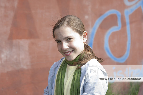 Lächelndes Mädchen vor einer Graffitiwand  Portrait