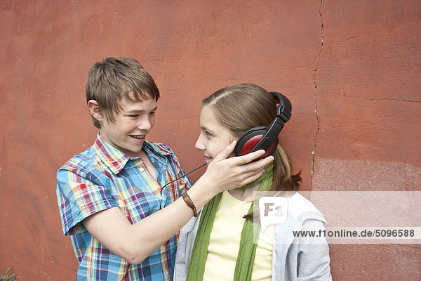 Junge und Mädchen teilen Kopfhörer