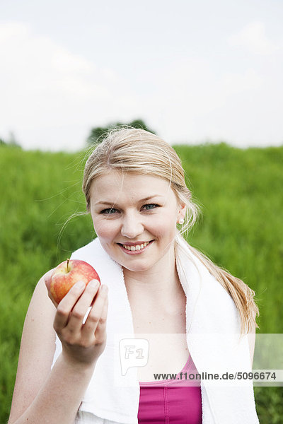 Junge Frau hält eine Apfel im Freien  Portrait