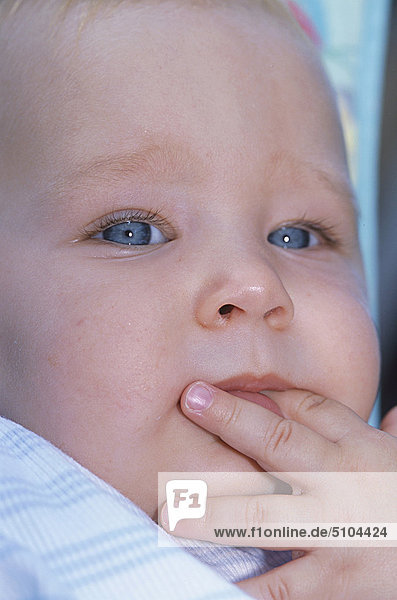Baby close up with fingers in mouth