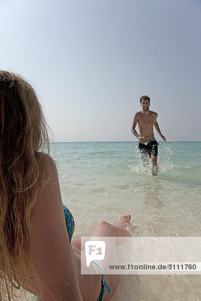 Couple playing in water on beach