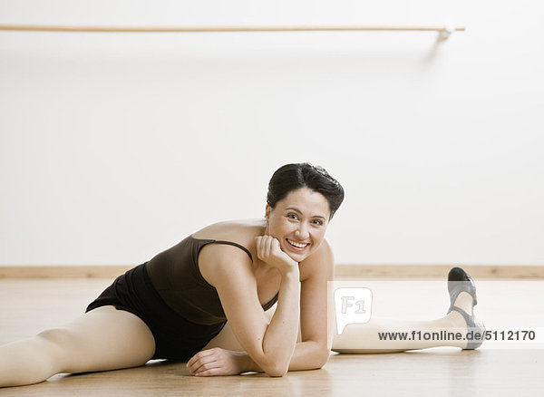 Tap dancer stretching on studio floor