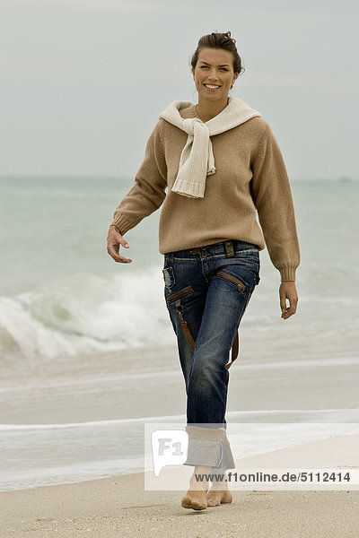 Junge Frau zu Fuß am Strand