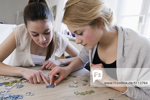Teenage girls working on jigsaw puzzle