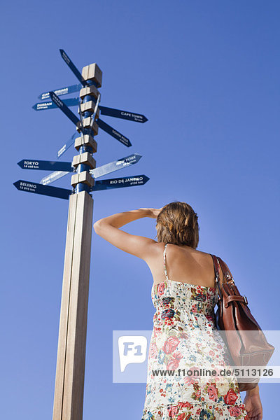 Woman reading directions at crossroads