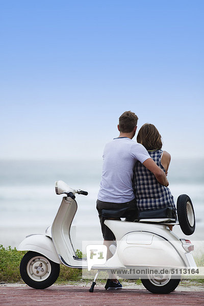 Couple sitting on scooter together