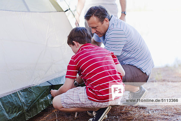 Vater und Sohn bauen gemeinsam ein Zelt auf