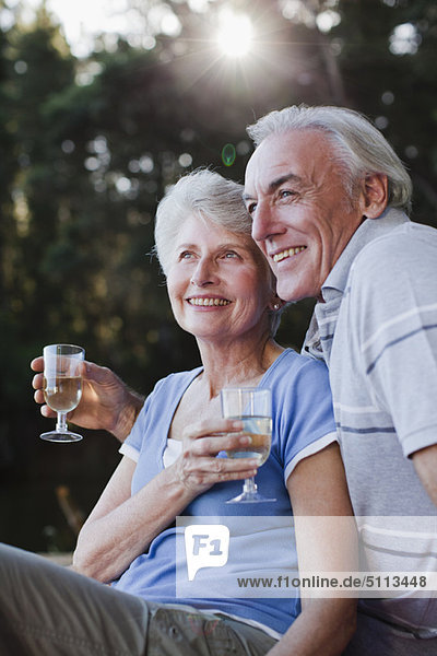 Älteres Paar trinkt Wein im Freien