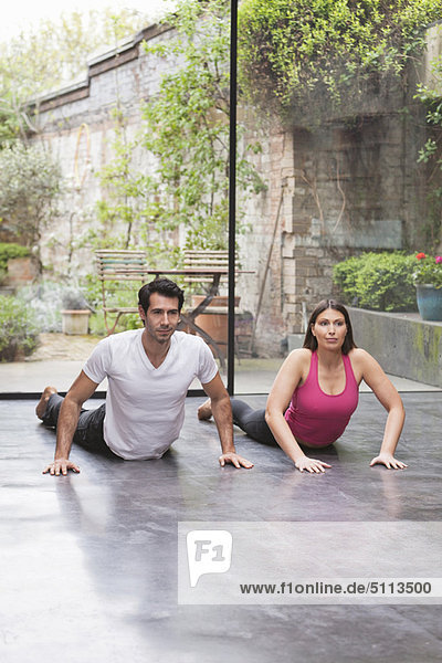 Couple practicing yoga together at home