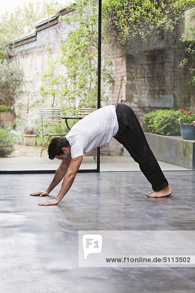 Man practicing downward dog yoga pose