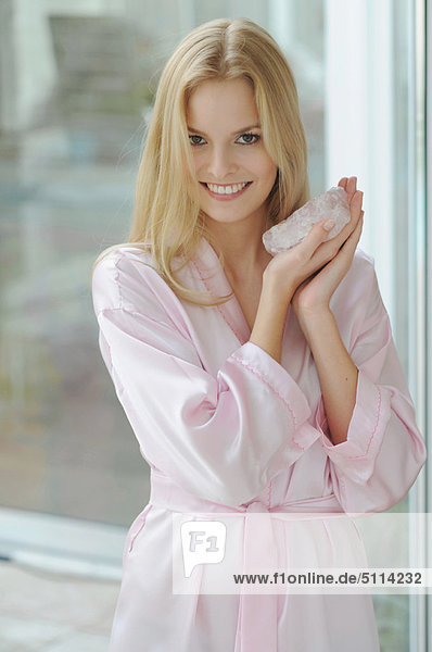 Smiling woman holding rose quartz