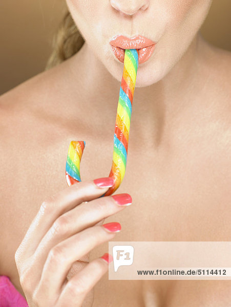 Woman in lipstick eating candy cane