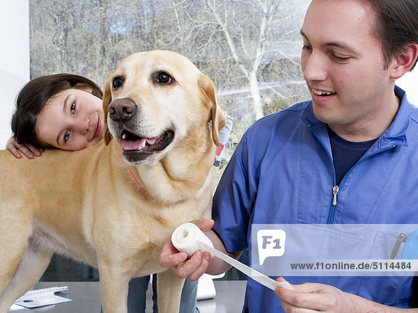 Tierarzt bei der Arbeit mit Mädchen und Hund