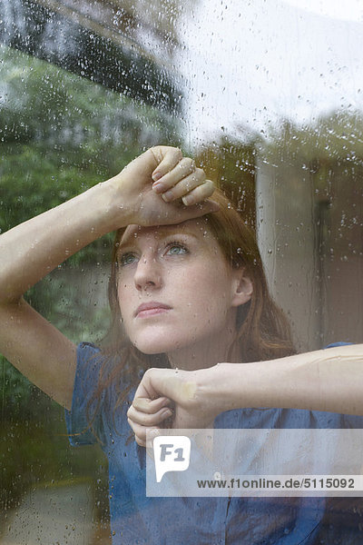 Woman looking outside on rainy day