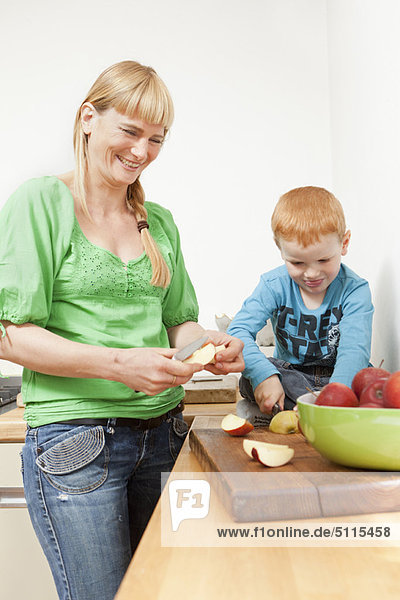 Mutter und Sohn beim Apfelschneiden