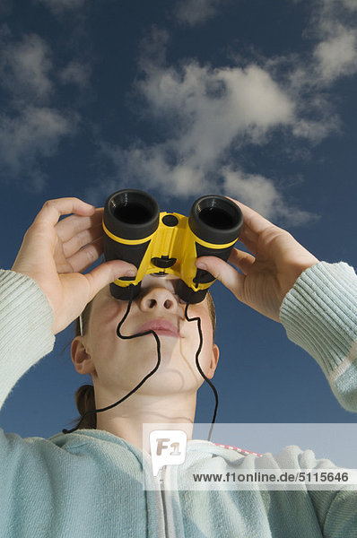 Girl using binoculars outdoors