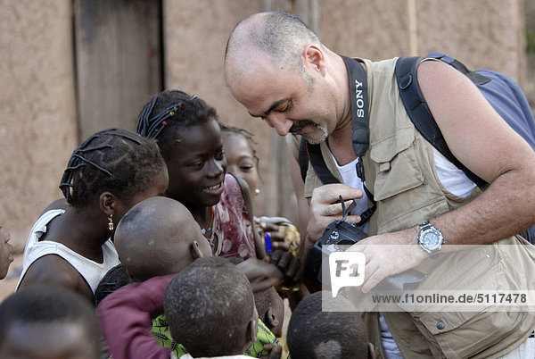 Afrika  Burkina Faso  Fotograf mit digitale Bildern in lokalen Menschen im Dorf