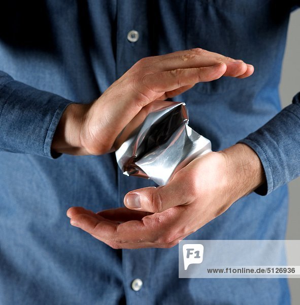 Man squashing a can with his hands