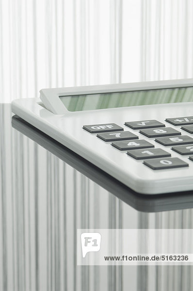 Close up of pocket calculator with reflection on table