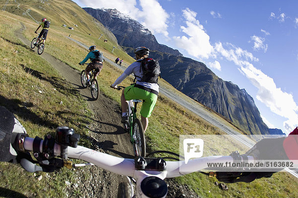 Italy  Livigno  View of woman and man riding mountain bike downhill