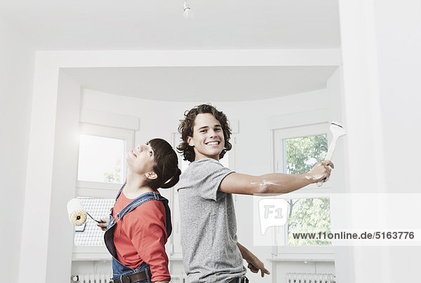 Germany  Cologne  Young couple painting in renovating apartment