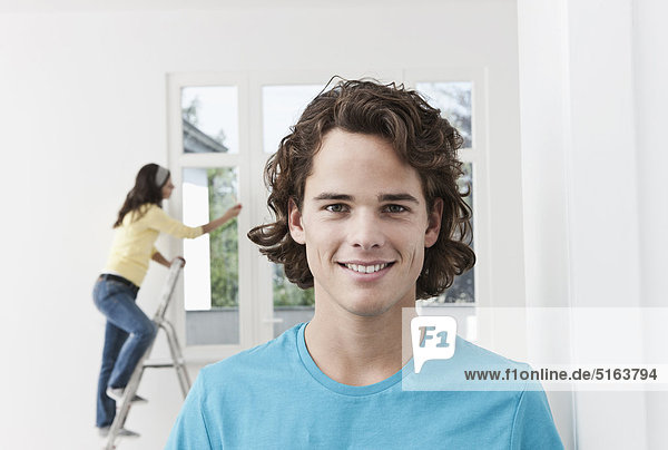 Nahaufnahme eines jungen Mannes und einer jungen Frau im Hintergrund bei der Renovierung der Wohnung