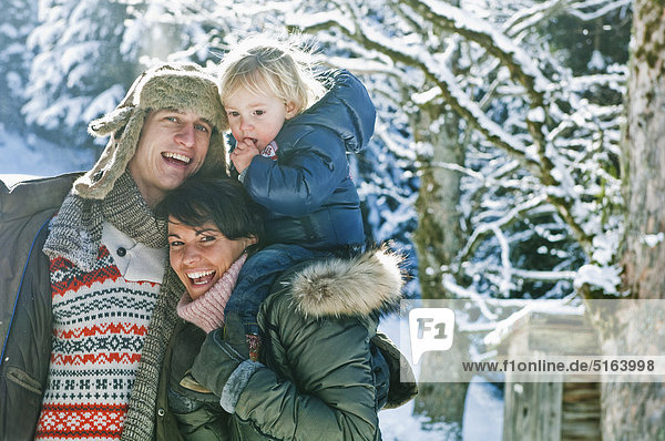 Österreich  Salzburger Land  Flachau  Familie im Schnee stehend  lächelnd