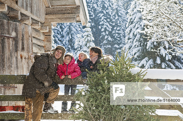 Österreich  Salzburger Land  Flachau  Familie am Zaun im Schnee