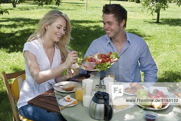 Junges Paar frühstückt im Park