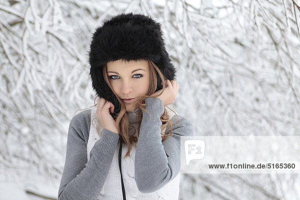 Young woman with cap in snow