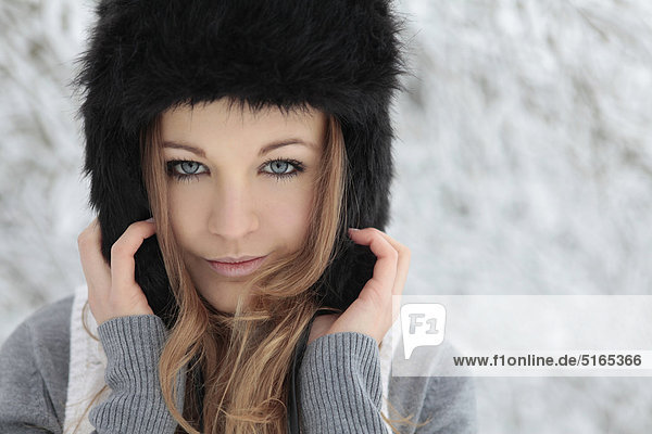 Young woman with cap in snow