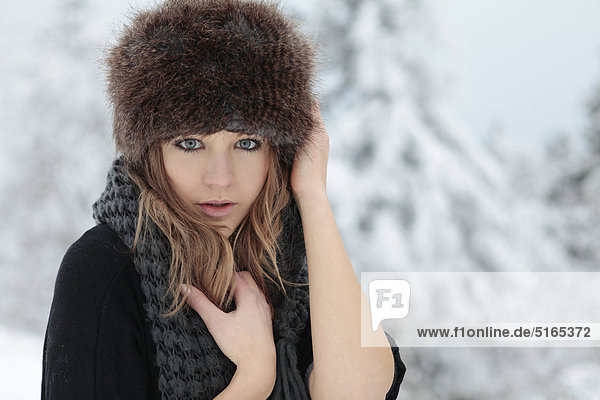 Young woman with scarf and cap in snow