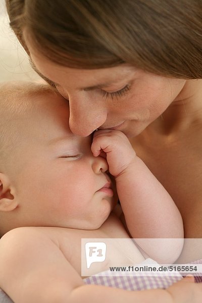 Mutter küsst schlafendes Baby
