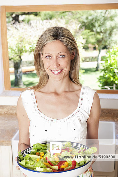Frau mit Salat in der Küche