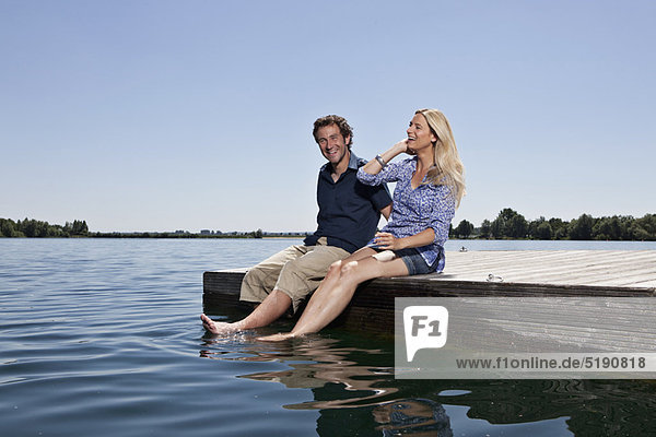 Couple relaxing together on dock