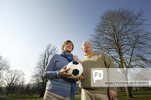Älteres Paar spielt mit Fußball