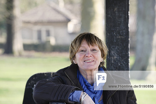 Ältere Frau auf Parkbank sitzend