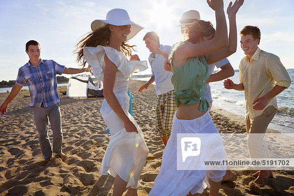 People dancing together on beach