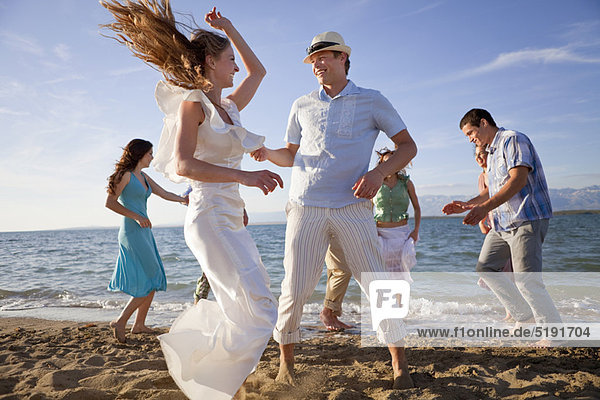 Newlywed couple on beach with friends