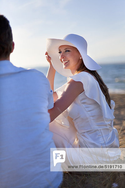 Bride sitting on beach