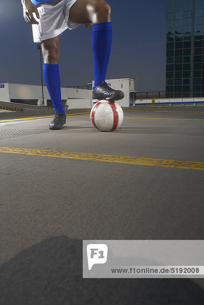 Soccer player with ball on rooftop