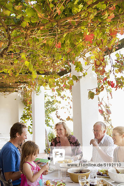 Family eating at table outdoors