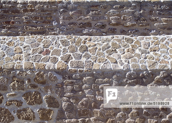 Natursteinmauer mit hellerem Absatz