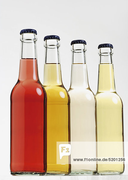 Vier Flaschen mit farbigen Biodrinks