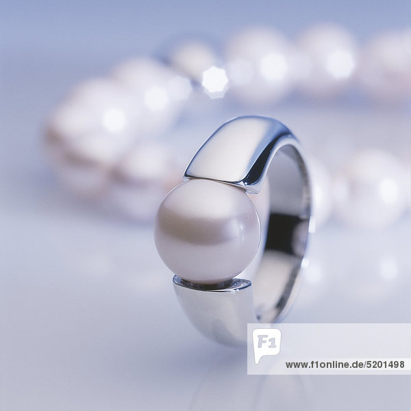 Perlenring,  Perlenkette im Hintergrund